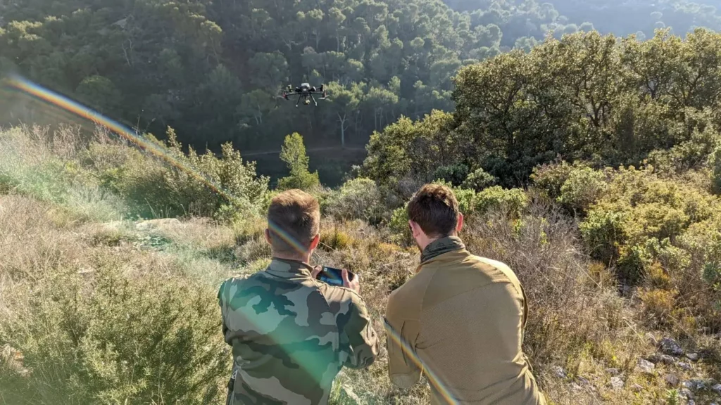 two trainees from the drone crew initiation and training center flying a drone in the mountains
